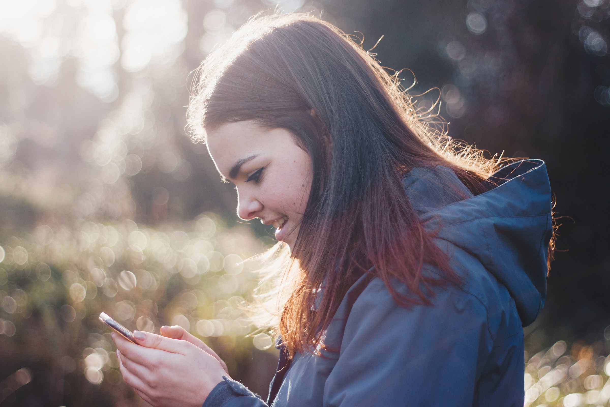 woman looking at phone and smiling